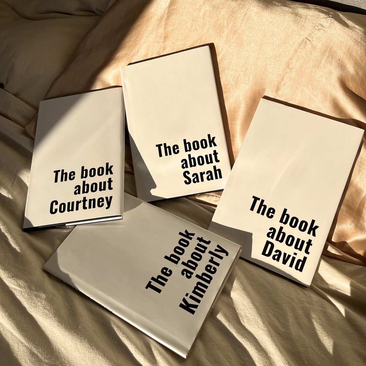 Four personalized Human Design guidebooks with different names on the covers